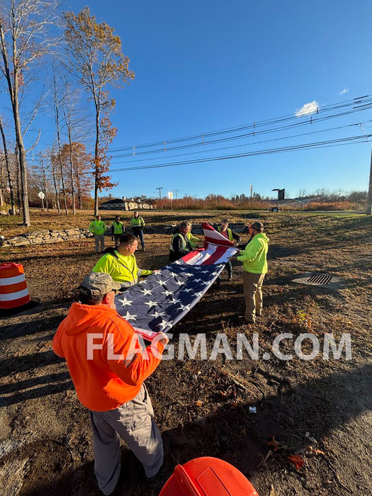 Large American flag being folded by a group of people
