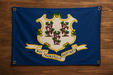 Realistic Connecticut flag with brass grommets in all 4 corners mounted to a wood wall