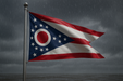 Heavy duty Ohio flag for sale flying on a flagpole in rainy and windy conditions