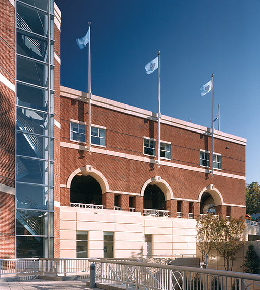Vertical wall mounted aluminum flagpoles installed on commercial brick building