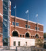 Vertical wall mounted aluminum flagpoles installed on commercial brick building